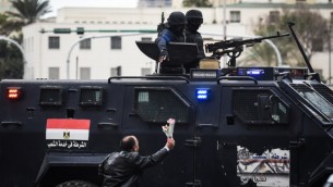 رجل مصري داعم للحكومة يقدم الازهار لقوات الشرطة الخاصة التي تحرس ميدان التحرير في القاهرة في يوم ذكرى الثورة، 25 يناير 2016 (MOHAMED EL-SHAHED / AFP)