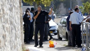 من الأرشيف: القوات الإسرائيلية تقف إلى جانب جثة فلسطيين حاول طعن عنصر من شرطة حرس الحدود في حي أرمون هنتسيف في القدس، 17 أكتوبر، 2015. (AFP/AHMAD GHARABLI)