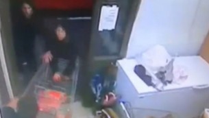 مردخاي شاليم (أسفل الصورة من اليسار) يصارع منفذي هجوم بواسطة عربة تسوق خلال هجوم في بيت حورونن 25 يناير، 2016. (لقطة شاشة)