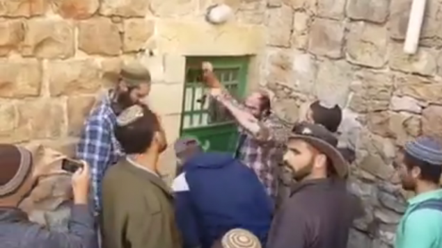 مستوطنون في الخليل يدخلون بالقوة إلى عدد من المباني بإدعاء أنه تم شراؤها بشكل سري في 21 يناير، 2016. (لقطة شاشة: YouTube) مستوطنون في الخليل يدخلون بالقوة إلى عدد من المباني بإدعاء أنه تم شراؤها بشكل سري في 21 يناير، 2016. (لقطة شاشة: YouTube)