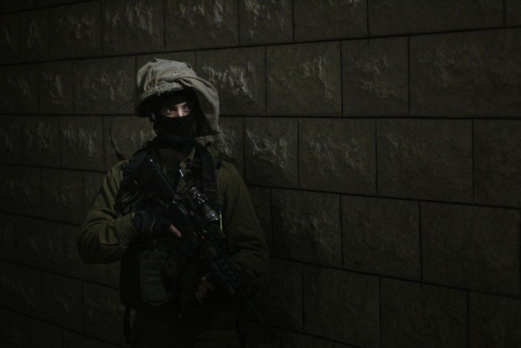 جندي يتهيأ للدخول الى منزل مراهق فلسطيني متهم برشق جنود اسرائيليين بالحجارة خلال مظاهرة في قلقيلية. دخلت فرقة اولية المنزل قبل ذلك لإيقاظ العائلة، التي نفت في بداية الامر ان الابن متواجد في المنزل، 14 يناير 2016 (Judah Ari Gross/Times of Israel)