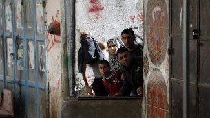 صورة توضيحية - فلسطينيون يشاهدون اشتباكات بين متظاهرين والجيش الإسرائيلي في مخيم الامعري بالقرب من رام الله في الضفة الغربية، 15 فبراير 2016 (ABBAS MOMANI / AFP)