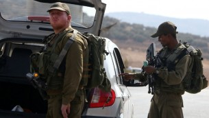 جنود اسرائيليون يفتشون سيارة فلسطينية في حاجز في الضفة الغربية، 2 اكتوبر 2015 (AFP/Jaafar Ashtiyeh)