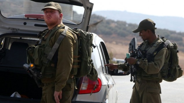 جنود اسرائيليون يفتشون سيارة فلسطينية في حاجز في الضفة الغربية، 2 اكتوبر 2015 (AFP/Jaafar Ashtiyeh)