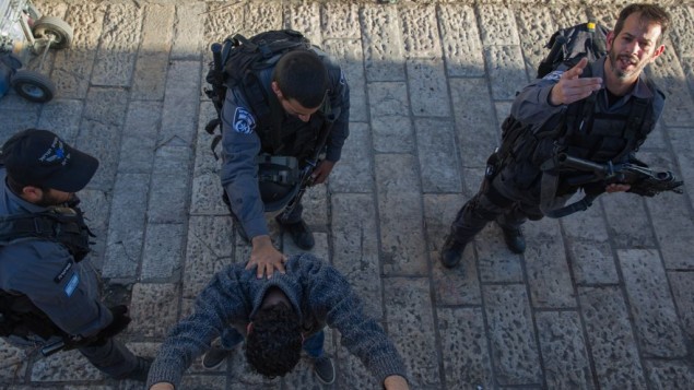 عناصر شرطة يفتشون رجل فلسطيني في باب العامود في القدس، 15 فبراير 2016 (Nati Shohat/Flash90)