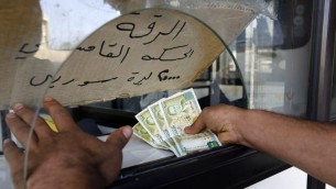 رجل يشتري تذكرة لحافلة تمر في عدة مناطق سورية، في محطة شارل حلو في بيروت، 18 مارس 2016 (ANWAR AMRO / AFP)