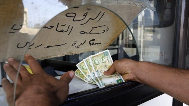 رجل يشتري تذكرة لحافلة تمر في عدة مناطق سورية، في محطة شارل حلو في بيروت، 18 مارس 2016 (ANWAR AMRO / AFP)