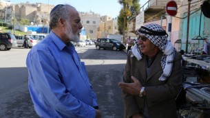 رجلان يهودي وعربي خارج الحرم الإبراهيمي في الخليل، 10 ديسمبر، 2014. (Gershon Elinson/Flash90)