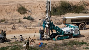 جنود اسرائيليون يحرسون بينما يتم الحفر في الارض على الطرف الإسرائيلي من الحدود مع قطاع غزة بحثا عن انفاق، 10 فبراير 2016 (AFP PHOTO/MENAHEM KAHANA)