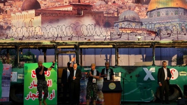 اسماعيل هنية خلال مهرجان لحركة حماس في غزة، امام صورة لحافلة في القدس تم تفجيرها، 28 ابريل 2016 (AFP PHOTO / MOHAMMED ABED)