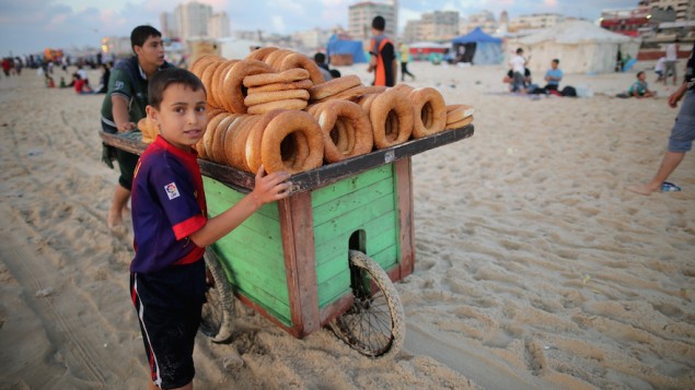 اطفال يبيعون الخبز على شاطئ غزة، 13 يونيو 2015 (Christopher Furlong/Getty Images via JTA)