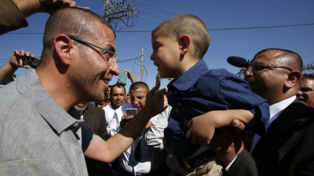 الصحافي الفلسطيني محمد القيق الذي اضرب عن الطعام لاكثر من ثلاثة اشهر احتجاجا على اعتقاله الاداري، يعانق طفله عند وصوله بلدته، دورا، في الضفة الغربية بعد اطلاق سراحه، 19 مايو 2016 (HAZEM BADER / AFP)
