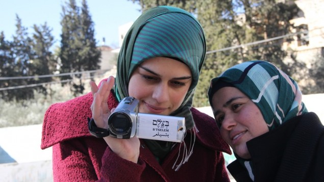 ناشطتان فلسطينيتان في منظمة بتسيلم لحقوق الانسان تستخدمان كاميرا لتوثيق نشاطات الحش والمستوطنين الإسرائيليين في الضفة الرغبية، 2014 (B'Tselem/CC BY 4.0)