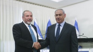 رئيس الوزراء بينيامين نتنياهو (من اليمين) ورئيس حزب ’إسرائيل بيتنا’ أفيغدور ليبرمان يتصافحان بعد التوقيع على اتفاق انضمام حزب ليبرمان للحكومة في الكنيست الأربعاء، 25 مايو، 2016. (Yonatan Sindel/Flash90)