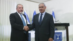 رئيس الوزراء بنيامين نتنياهو يصافح رئيس حزب يسرائيل بيتينو بعد التوقيع على اتفاق ائتلافي في الكنيست، 25 مايو 2016 (Yonatan Sindel/FLASH90)