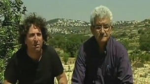 المستوطن اليهودي إباز كوهين، من اليسار، والعضو في منظمة التحرير الفلسطينية محمد البيروتي يجلسان معا بالقرب من إفرات، في الضفة الغربية. الرجلان ناشطان في الحركة الجديدة ’دولتان ووطن واحد’ يسيران باتجاه الجدار الفاصل الذي يفصل الضفة الغربية عن إسرائيل. (لقطة شاشة من القناة 2)