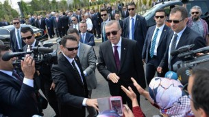 الرئيس التركي رجب طيب أردوغان، في الوسط، يحيي مؤيديه عند وصوله إلى حفل افتتاح مسجد بايزيد (يلدريم بايزيد) في مطار إيسينبوغا الدولي في أنقرة، 23 يونيو، 2016. (Adem Altan/AFP)