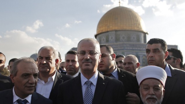 من الأرشيف: رئيس الوزراء الفلسطيني رامي حمد الله (في الوسط) يقف إلى جانب مفتي القدس محمد حسين (من اليمين) أمام قبة الصخرة في 27 أكتوبر، 2014. (AFP/Ahmad Gharabli) من الأرشيف: رئيس الوزراء الفلسطيني رامي حمد الله (في الوسط) يقف إلى جانب مفتي القدس محمد حسين (من اليمين) أمام قبة الصخرة في 27 أكتوبر، 2014. (AFP/Ahmad Gharabli)