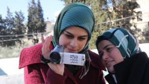 متطوعتان فلسطينيتان في منظمة ’بتسيلم’ لحقوق الإنسان تتعلمان كيفية إستخدام كاميرات فيديو لتوثيق أنشطة الجيش الإسرائيلي والمستوطنين الإسرائيليين في الضفة الغربية، في 2014. (B'Tselem/CC BY 4.0)