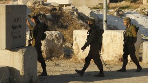 صورة توضيحية: جنود اسرائيليون يقيمون حاجزا امنيا عند المدخل الجنوبي لمدينة الخليل في الضفة الغربية، 2 يوليو 2016 (HAZEM BADER / AFP)
