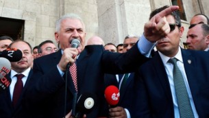 رئيس الوزلراء التركي بن علي يلدريم (في الوسط) يتحدث إلى الجمهور بعد لقاء مع رئيس البرلمان التركي في مجلس الأمة التركي الكبير في أنقرة، 16 يوليو، 2016 في أعقاب محاولة إنقلاب عسكري فاشلة. (AFP PHOTO / ADEM ALTAN)