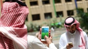 شابان سعوديان يلعبان تطبيق ’بوكيمون غو’ على هاتفهما المحمولين في العاصمة الرياض، 17 يوليو، 2016. (AFP PHOTO / STRINGER)