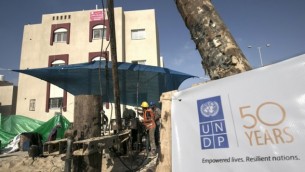 عمال بناء فلسطينيين يعملون على بئر مياه في مشروع إسكان ممول من السعودية ويتم تنفيذه من قبل برنامج الأمم المتحدة الإنمائي (UNDP)، في رفح جنوبي قطاع غزة، 9 أغسطس، 2016. (AFP Photo/Said Khatib)