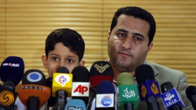 Shahram Amiri, an Iranian nuclear scientist attends a news briefing while holding his son Amir Hossein as he arrives at the Imam Khomeini airport just outside Tehran, Iran, after returning from the United States on July 15, 2010. AP/Vahid Salemi