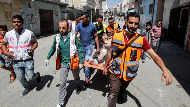 مشعفون يخلون فلسطينيا اصيب خلال اشتباكات مع الجيش الإسرائيلي في مخيم الفوار جنوب الخليل، 16 اغسطس 2016 (Wisam Hashlamoun/Flash90)