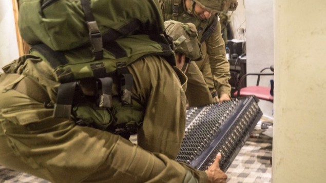 جنود اسرائيليون يصادرون معدات بث بينما يغلقون اضاعة السنابل في دورا، 31 اغسطس 2016 (IDF Spokesperson's Unit)