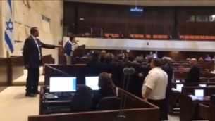 عضو الكنيست حنين زعبي (القائمة المشتركة)، في الوسط، خلال شجار مع أعضاء كنيست آخرين في قاعة الكنسيت بسبب تصريحاتها حول إتفاق المصالحة الإسرائيلي-التركي، 29 يونيو، 2016. (لقطة شاشة: YouTube)