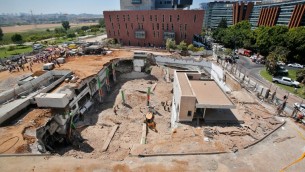 مسعفون ووحدات طوارئ يعملون في موقع بناء حيث انهار موقف سيارات تحت ارضي في حي رمات هحايال في تل ابيب، 5 سبتمبر 2016 (AFP PHOTO / GIL COHEN-MAGEN)