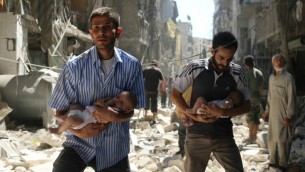 رجال سوريون يحملون اطفال يمرون بين الحطام بعد غارات جوية في مدينة حلب السورية، 11 سبتمبر 2016 (Ameer Alhalbi/AFP)