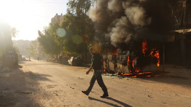 رجل سوري يمر امام حافلة مشتعلة بعد غارات جوية في شرق حلب، 25 سبتمبر 2016 (AFP/AMEER ALHALBI) رجل سوري يمر امام حافلة مشتعلة بعد غارات جوية في شرق حلب، 25 سبتمبر 2016 (AFP/AMEER ALHALBI)