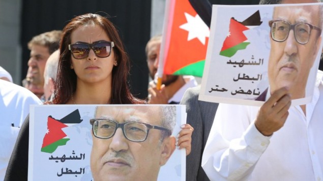 متظاهرون يحملون صورة الكاتب الاردني ناهض حتر