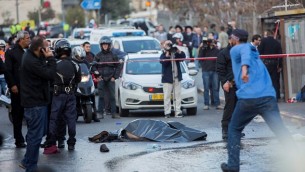 جثة منفذ هجوم فلسطيني ملقاة على الأرض بعد إطلاق النار عليه وقتله بينران عناصر الأمن الإسرائيليين خلال هجوم عند مدخل القدس، 14 ديسمبر، 2015، أدى إلى إصابة 14 شخصا، من بينهم طفل رضيع. (Yonatan Sindel/Flash90)