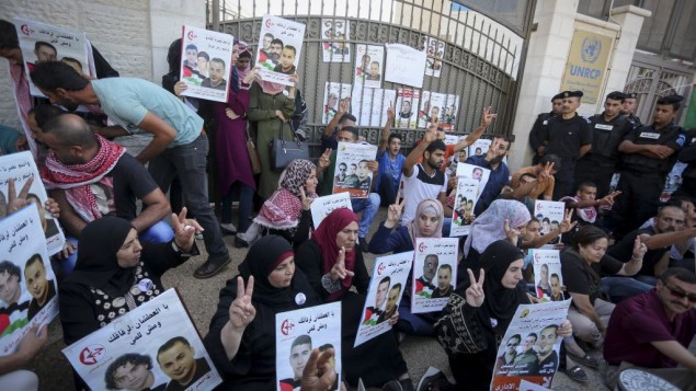 فلسطينيون يحملون لافتات ضد الإعتقال الإداري ودعما للأسرى الفلسطينيين بلال كايد ومحمد ومحمود البلبول أمام مبنى الأمم المتحدة في مدينة رام الله في الضفة الغربية، 22 أغسطس، 2016. (Flash90) فلسطينيون يحملون لافتات ضد الإعتقال الإداري ودعما للأسرى الفلسطينيين بلال كايد ومحمد ومحمود البلبول أمام مبنى الأمم المتحدة في مدينة رام الله في الضفة الغربية، 22 أغسطس، 2016. (Flash90)