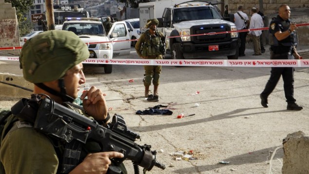 جنود إسرائيليون وقوات أمن في موقع هجوم طعن في مدينة الخليل بالضفة الغربية، 17 سبتمبر، 2016. (Wisam Hashlamoun/Flash90) جنود إسرائيليون وقوات أمن في موقع هجوم طعن في مدينة الخليل بالضفة الغربية، 17 سبتمبر، 2016. (Wisam Hashlamoun/Flash90)
