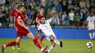 لاعب خط الوسط الإسرائيلي عيران زهافي (وسط الصورة) يمرر الكرة من أمام لاعب خط وسط ليختنشاين ساندرو وايز خلال مبارة  كرة قدم  في إطار تصفيات كأس العالم 2018  بين منتخبي إسرائيل وليختنشتاين في ملعب ’يدي كوليك’ في القدس، 9 أكتوبر، 2016. (AFP PHOTO / THOMAS COEX)