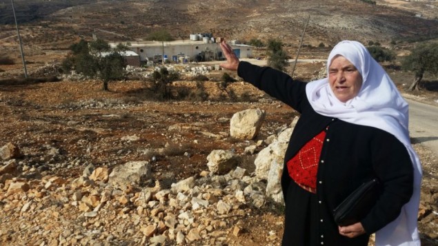 مريم حماد، من مدينة سلواد القريبة، تشير إلى قطعة أرض تقول إنها كانت ملكا لها قبل أن يقوم الإسرائيليون بالإستيلاء عليها وبناء مستوطنة عامونا، نوفمبر، 2016.  (Raphael Ahren/Times of Israel)