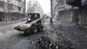 جرافة تزيل الحطام مع ابتداء الحكومة التنظيفات في مدينة حلب الشمالية، 27 ديسمبر 2016 (AFP/George Ourfalian)