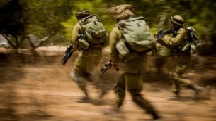 صورة للتوضيح: جنود يهرعون باتجاه هدف خلال حرب غزة في عام 2014، التي تُعرف في إسرائيل بإسم ’عملية الجرف الصامد’، 4 أغسطس، 2014. (وحدة المتحدث بإسم الجيش الإسرائيلي)