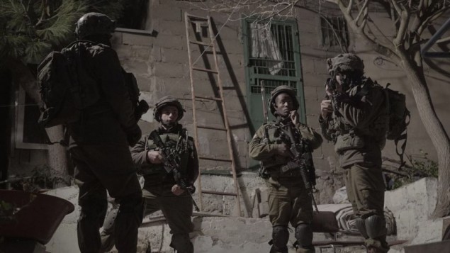 جنود اسرائيليون يحرسون بينما يتم اغلاق ورشة عمل يشتبه انها صنعت اسلحة غير قانونية في الخليل، 30 يناير 2017 (IDF Spokesperson's Unit)