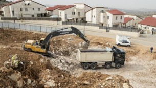 عمال فلسطينيون في موقع بناء لمشورع بناء وحدات سكنية جديدة في مستوطنة أريئيل بالقرب من مدينة نابلس في الضفة الغربية، 25 يناير، 2017. (AFP Photo/Jack Guez)