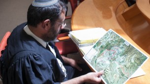 محام يدقق النظر في خريطة لمستوطنة بيت إيل قبل جلسة في المحكمة العليا في عام 2012. (Noam Moskowitz/Flash90)