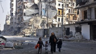سوريون يسيرون بين المباني المدمرة في حي طريق الباب في مدينة حلب، 18 يناير، 2017، بعد شهر من نجاح القوات الحكومية بإستعادة السيطرة على المدينة التي تقع شمال البلاد من المتمردين. (AFP Photo/George Ourfalian)