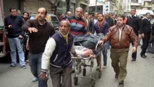 مصريون ينقلون جثمان بالقرب من كنيسة في الاسكندرية بعد تفجير استهدف المصلين خلال احد الشعانين، 9 ابريل 2017 (AFP Photo/Stringer)