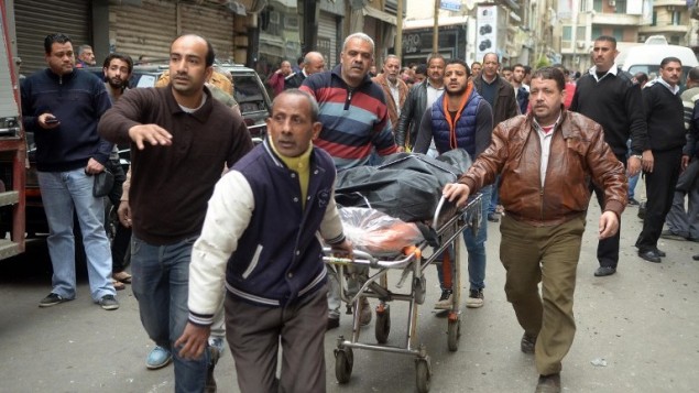 مصريون ينقلون جثمان بالقرب من كنيسة في الاسكندرية بعد تفجير استهدف المصلين خلال احد الشعانين، 9 ابريل 2017 (AFP Photo/Stringer)
