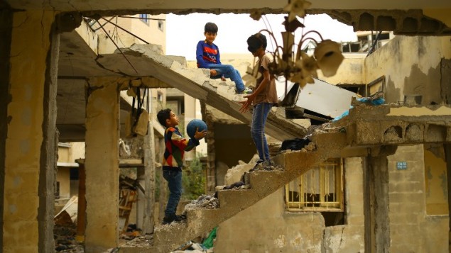 أطفال فلسطينيون يلعبون وسط أنفاض مبنى تم تدميره خلال حرب غزة 2014 في مدينة غزة، 13 أبريل، 2017. (AFP /MOHAMMED ABED) أطفال فلسطينيون يلعبون وسط أنفاض مبنى تم تدميره خلال حرب غزة 2014 في مدينة غزة، 13 أبريل، 2017. (AFP /MOHAMMED ABED)