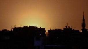 صورة تم إلتقاطها من بلدة دوما التي  يسيطر عليها المتمردون تظهر ألسنة النار عن بُعد والتي يُعتقد أنها تعلو من مطار دمشق الدولي التي تبعت انفجارا هز المنطقة في صباح 27 أبريل، 2017. (AFP PHOTO / Sameer Al-Doumy)